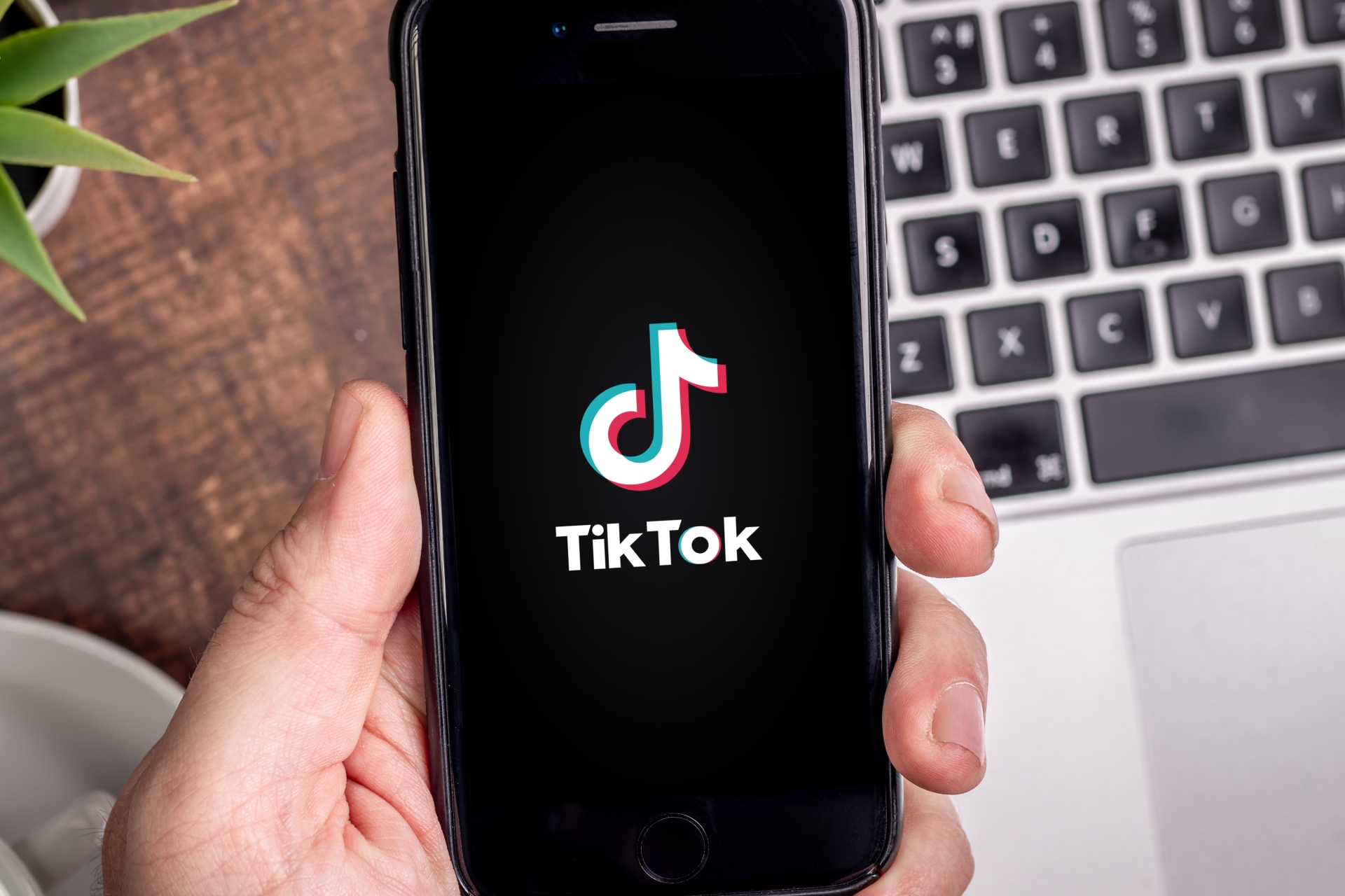 Smartphone-Display auf dem ein TikTok-Logo zu sehen ist.